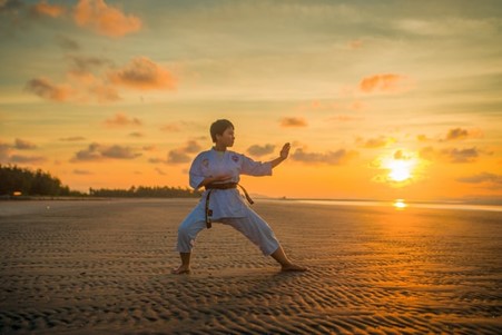 A person doing martial art on a beach